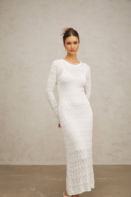 A white crochet knit midi dress with a flowing silhouette and intricate lace pattern