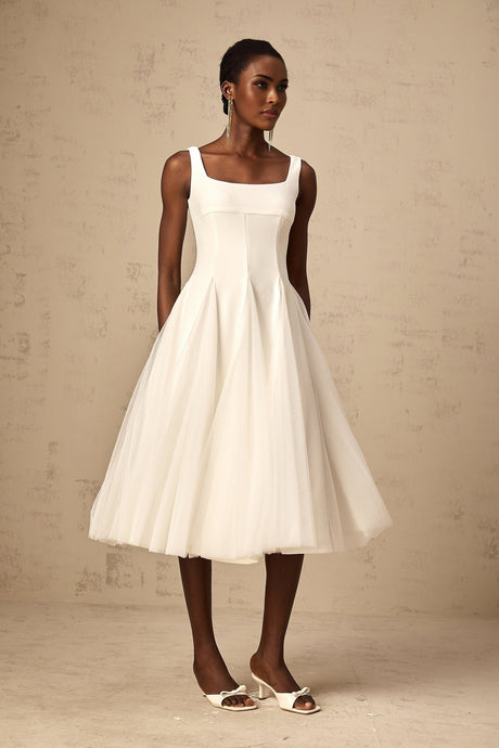 A white midi dress with a fitted bodice and flared tulle skirt featuring godet inserts named Danielle