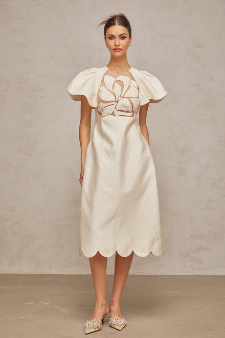 A white midi dress with a floral jacquard pattern featuring a fitted bodice and flared skirt