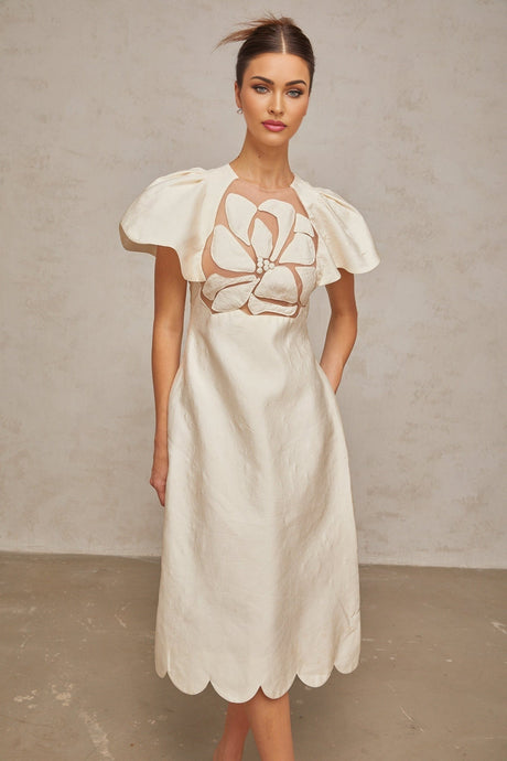 A white midi dress with floral jacquard pattern featuring a fitted bodice and flared skirt