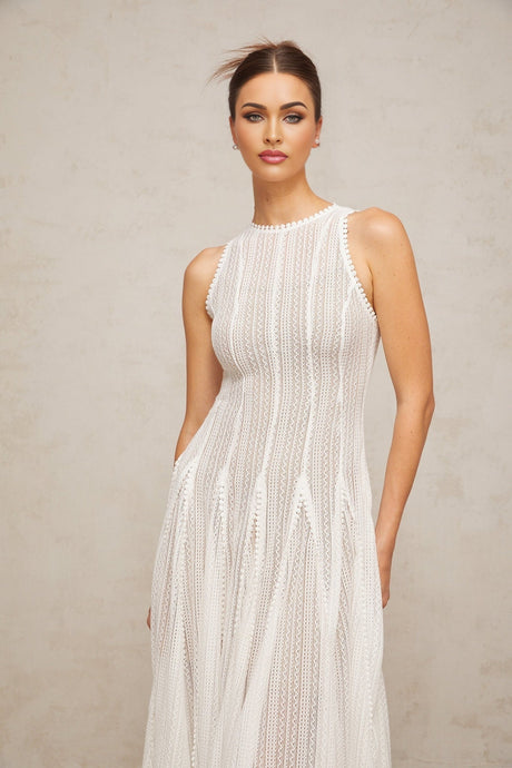 A white midi dress with puff sleeves and delicate pointelle knit detailing named Helene
