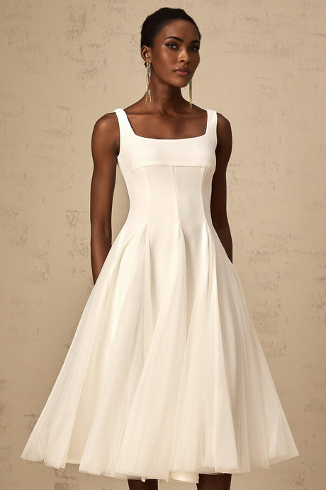 A white midi dress with tulle fabric and godet inserts featuring a fitted bodice and flared skirt