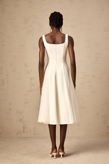 A white midi dress with tulle fabric featuring godet inserts and a flowy silhouette named Danielle