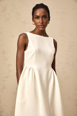 A white sleeveless midi dress with a full skirt worn by a model standing against a plain background