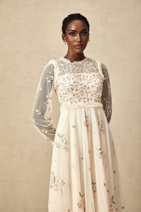 A white tulle midi dress with delicate floral embroidery featuring a Celine design with a sleeveless bodice and flowy skirt
