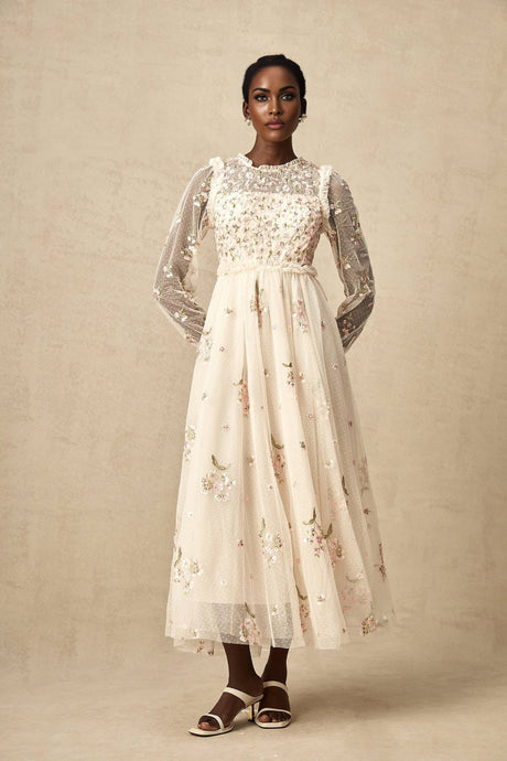 A white tulle midi dress with delicate floral embroidery featuring a fitted bodice and flowing skirt by Celine