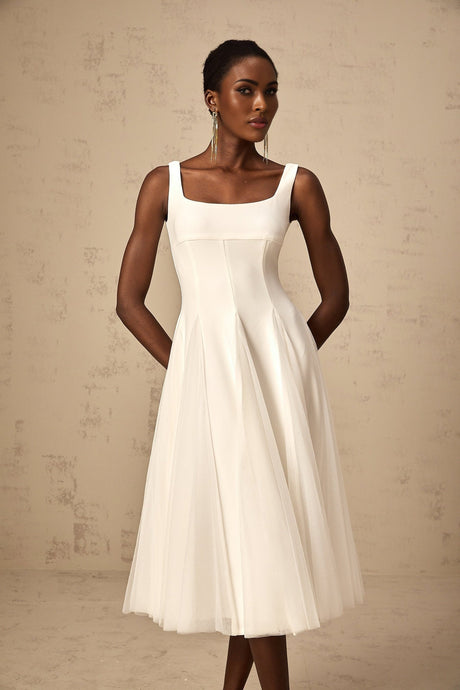 A white tulle midi dress with godet inserts featuring a fitted bodice and flared skirt named Danielle