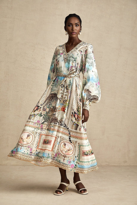 A woman wearing a belted midi dress with a V neckline in a casual yet elegant style