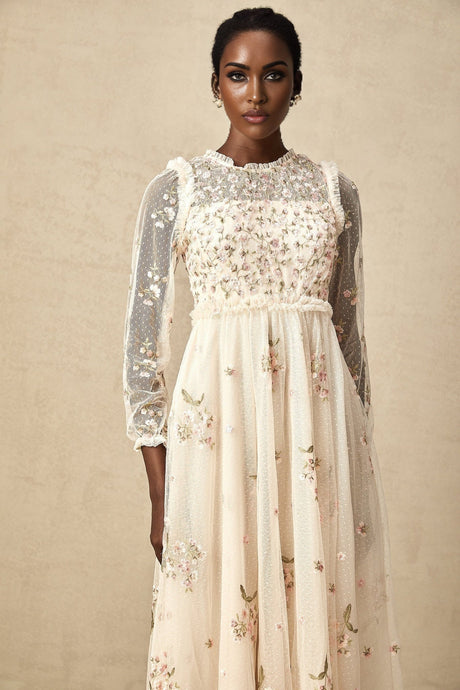 A woman wearing a Celine midi dress made of tulle fabric with delicate floral embroidery details throughout the bodice and skirt