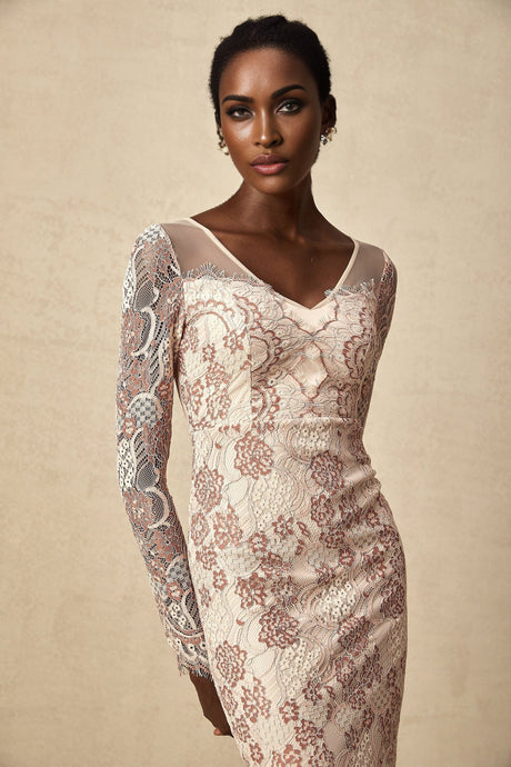 A woman wearing a fitted midi dress made of Anna guipure lace standing in a simple pose against a plain background