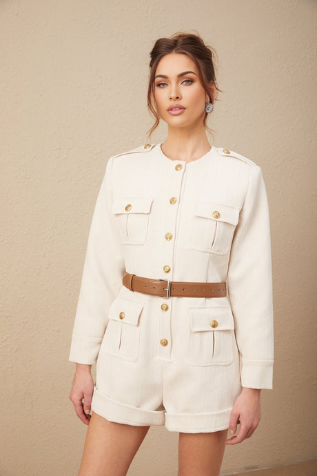 A woman wearing a fitted tweed bodysuit with long sleeves in a neutral color standing against a plain background