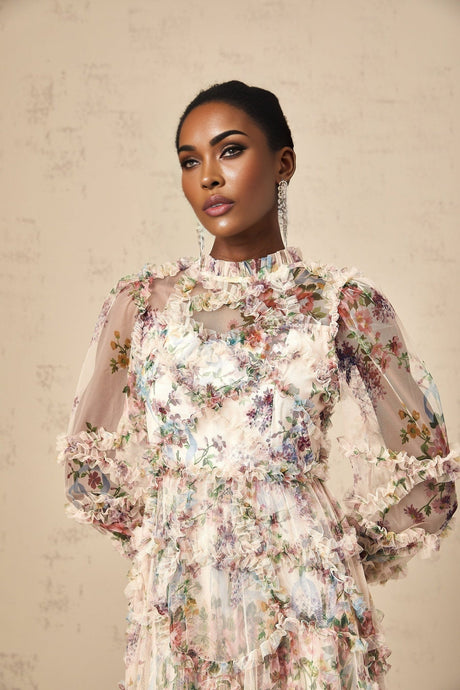 A woman wearing a floral patterned midi dress with ruffled details and a tulle skirt