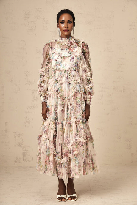 A woman wearing a floral patterned midi dress with ruffled details and a tulle skirt