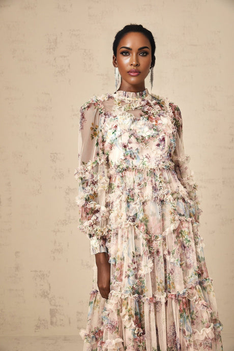 A woman wearing a floral patterned midi dress with ruffled tulle details and a delicate feminine design