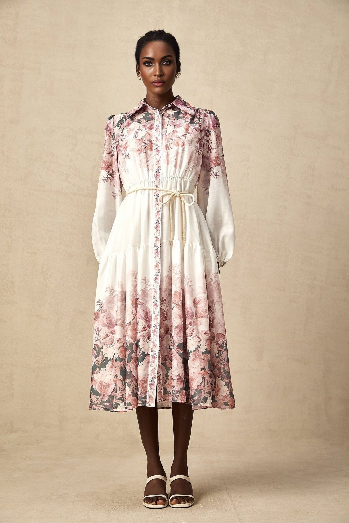 A woman wearing a floral print midi dress with lantern sleeves standing in a relaxed pose
