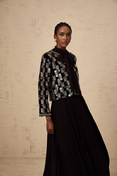 A woman wearing a matching sequined cardigan and dress set in a checkered pattern The outfit is sparkly and elegant suitable for formal occasions