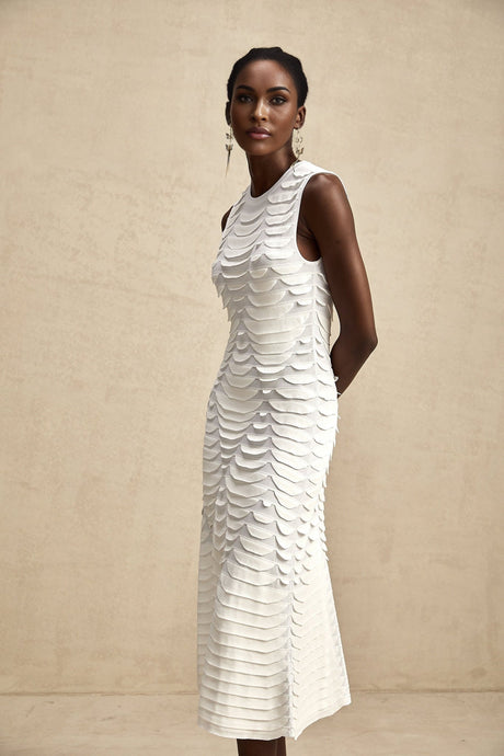 A woman wearing a midi length dress with a snake pattern print and godet flared skirt