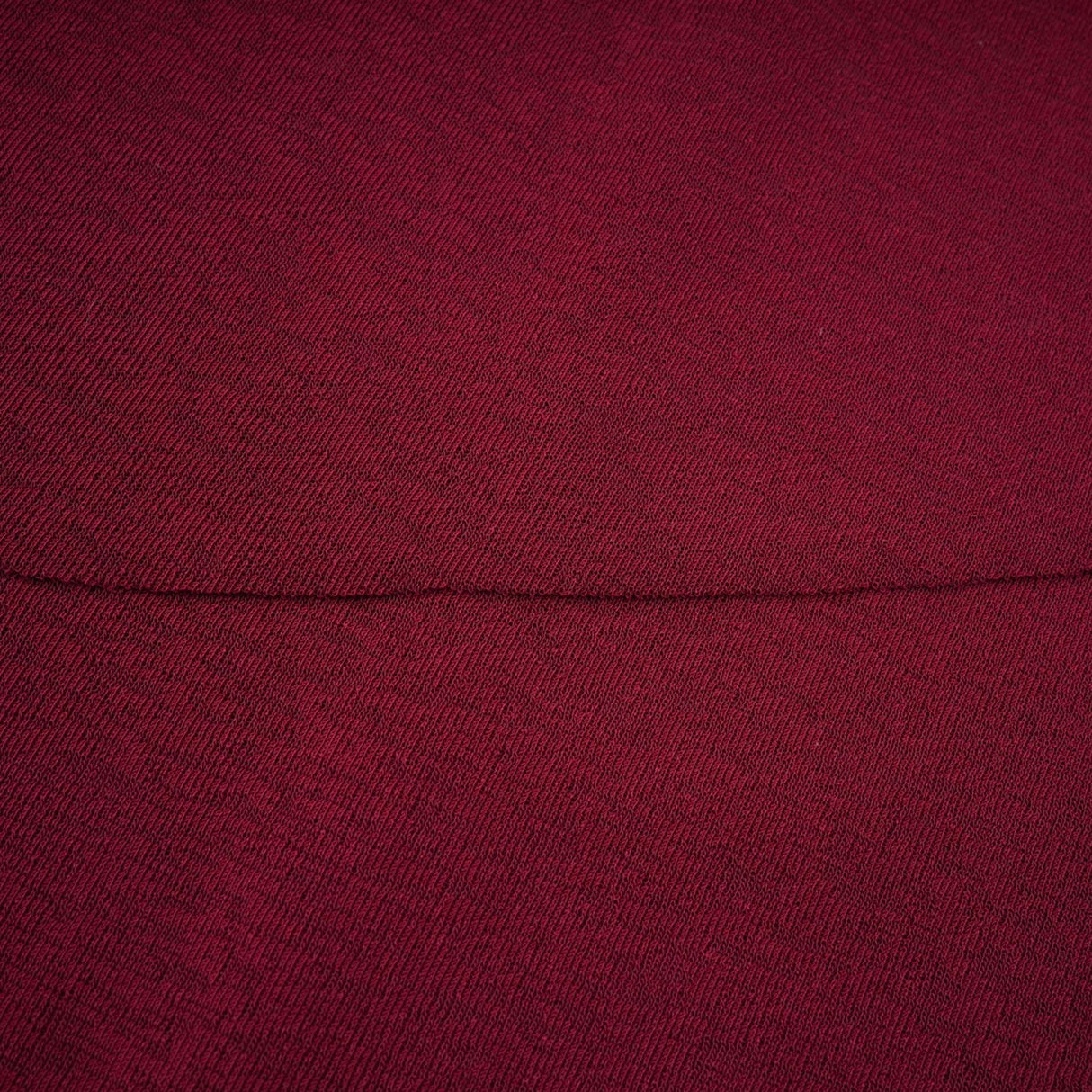 A woman wearing a red midi dress with ruched detailing and a flap design on the front