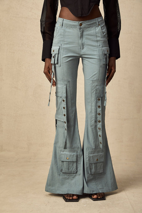 Beige flared cargo trousers with belt loops and multiple pockets worn by a model standing against a plain background