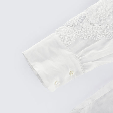 White blouse with lace embroidery and cut out details on the shoulders and sleeves