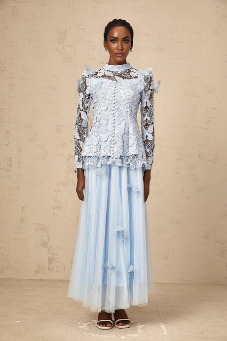 Woman wearing a blue sequined lace top and matching skirt set called Nicolette