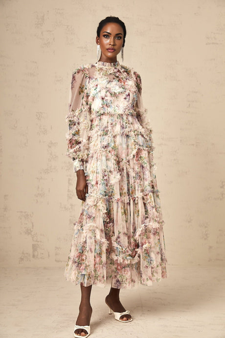 Woman wearing a floral patterned midi dress with ruffled details and tulle fabric