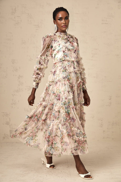 Woman wearing a floral patterned midi dress with ruffled tulle details and a feminine silhouette