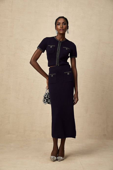 Woman wearing a matching ribbed knit top and skirt set with embellishments in a fitted silhouette