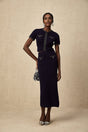 Woman wearing a matching ribbed knit top and skirt set with embellishments in a fitted silhouette