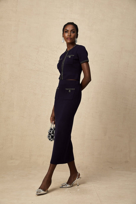 Woman wearing a matching ribbed knit top and skirt set with embellishments in a light color