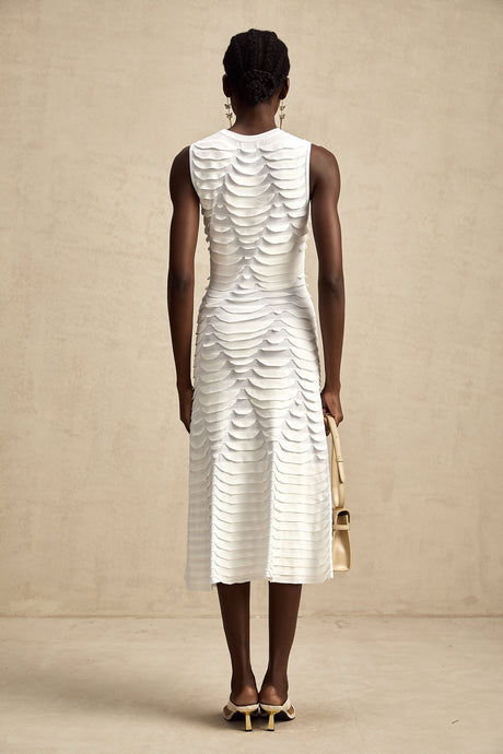 Woman wearing a midi length dress with snake pattern design featuring godet panels for a flared silhouette