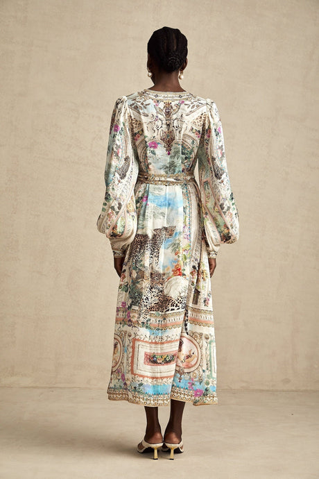 Woman wearing a midi length dress with Vneck and belt at waist