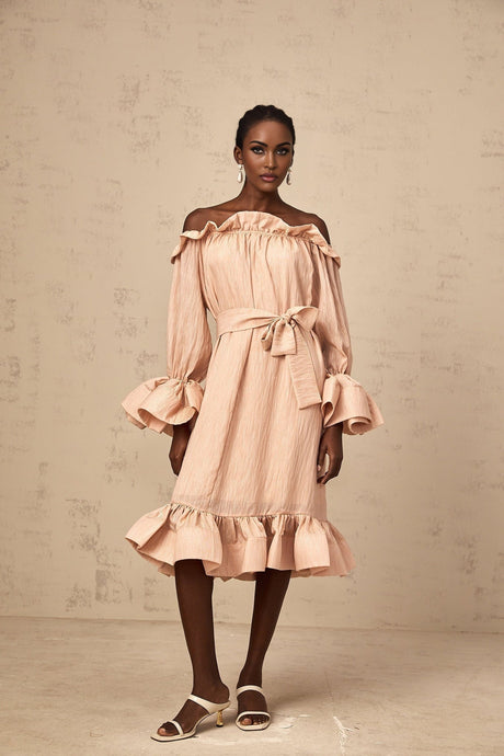 Woman wearing a pink midi dress with ruffled details and tied waist