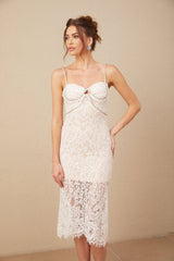 Woman wearing a white lace midi dress with crystal embellished bustier top and fitted silhouette
