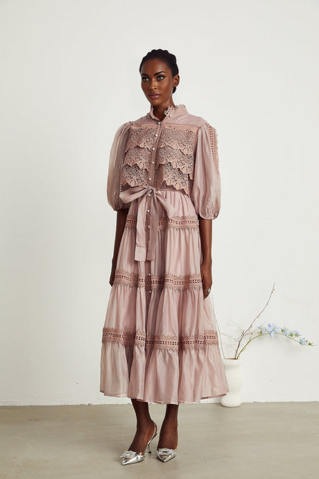 Woman wearing a white lace midi dress with tiered skirt and cutout details