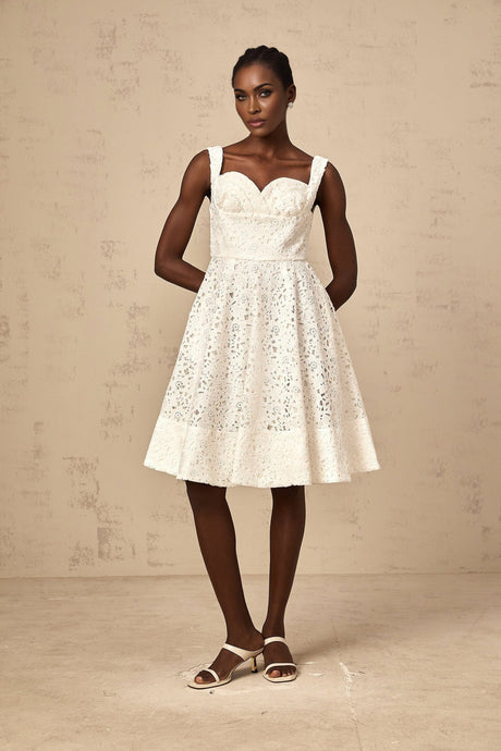 Woman wearing a white midi dress with floral lace pattern and sleeveless design