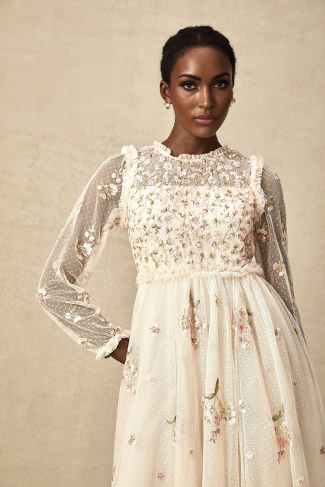 Woman wearing a white tulle midi dress with delicate floral embroidery details by Celine