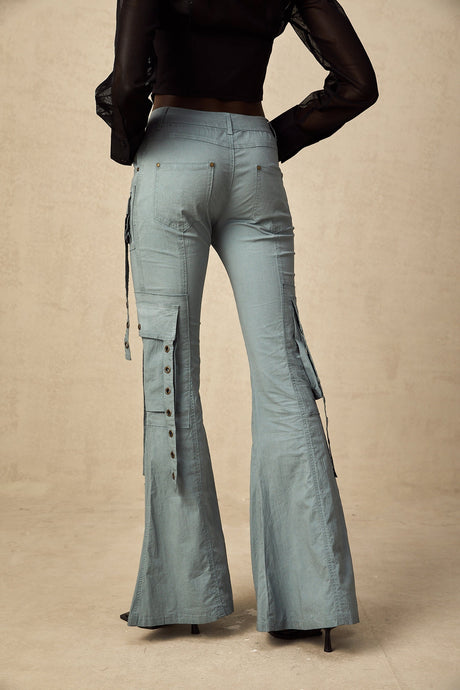 Woman wearing black flared cargo trousers with belt loops and multiple pockets standing in casual pose
