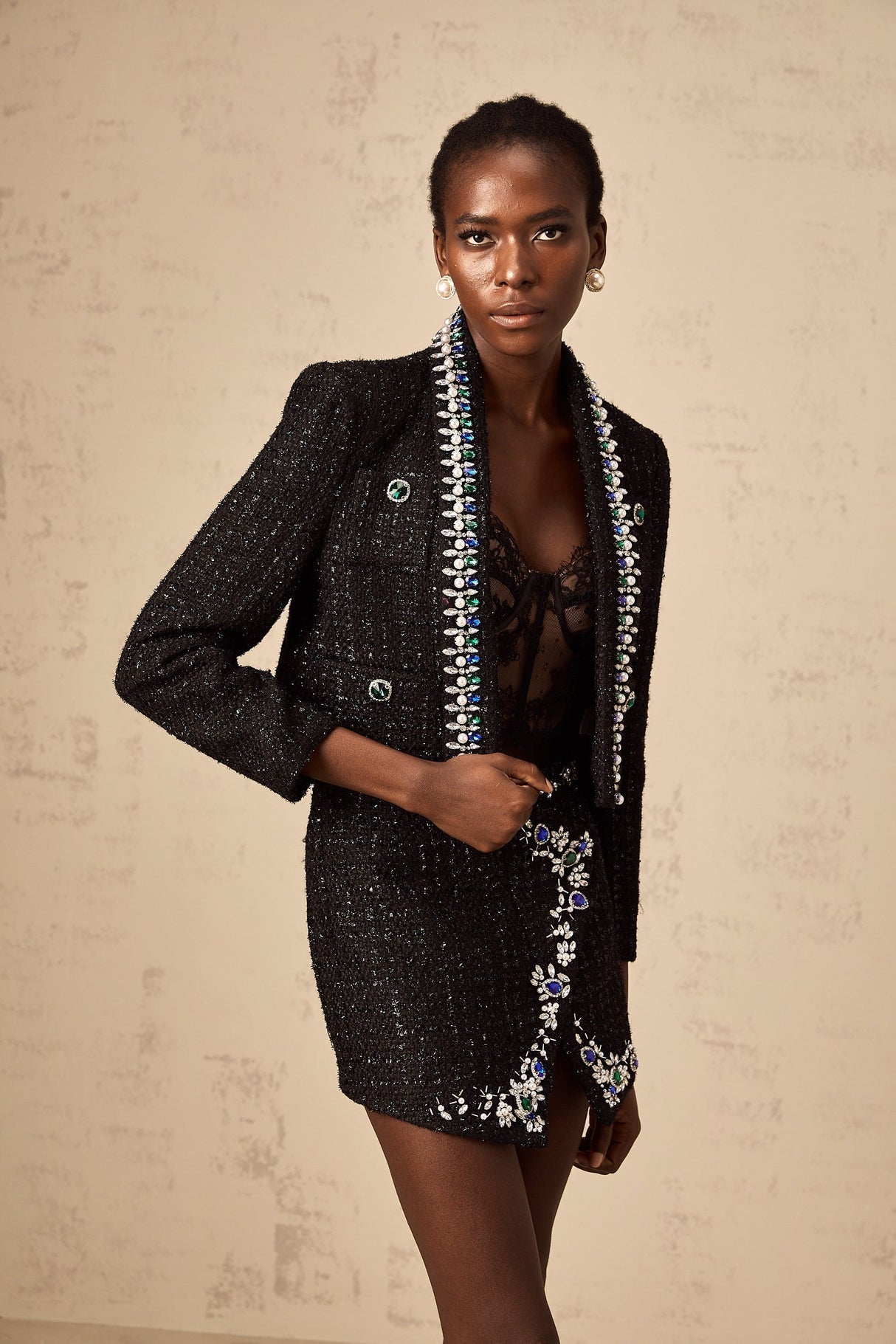 Woman wearing black tweed jacket and matching skirt set with crystal embellishments elegant formal outfit
