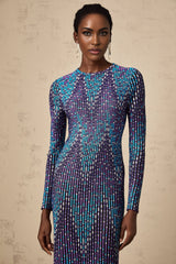 Woman wearing blue and white zigzag patterned knitted midi dress with long sleeves and round neckline