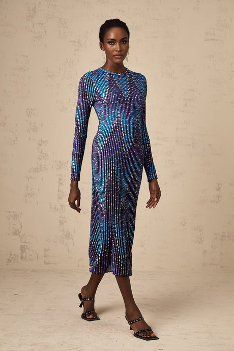 Woman wearing blue and white zigzag patterned knitted midi dress with long sleeves and round neckline
