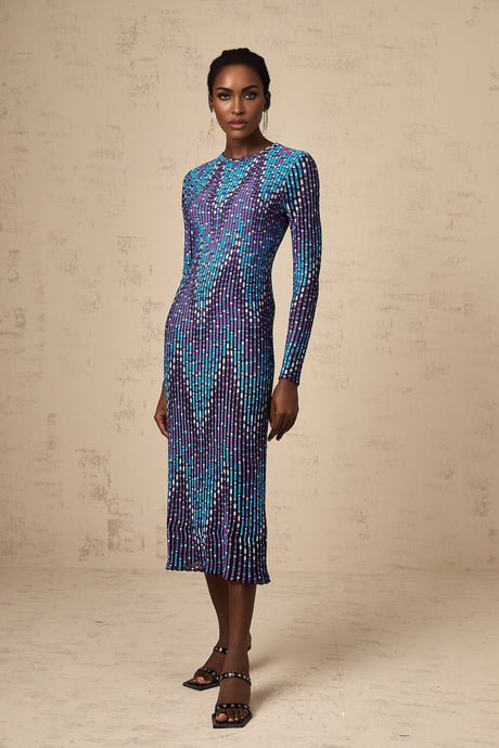 Woman wearing blue and white zigzag patterned knitted midi dress with long sleeves and round neckline