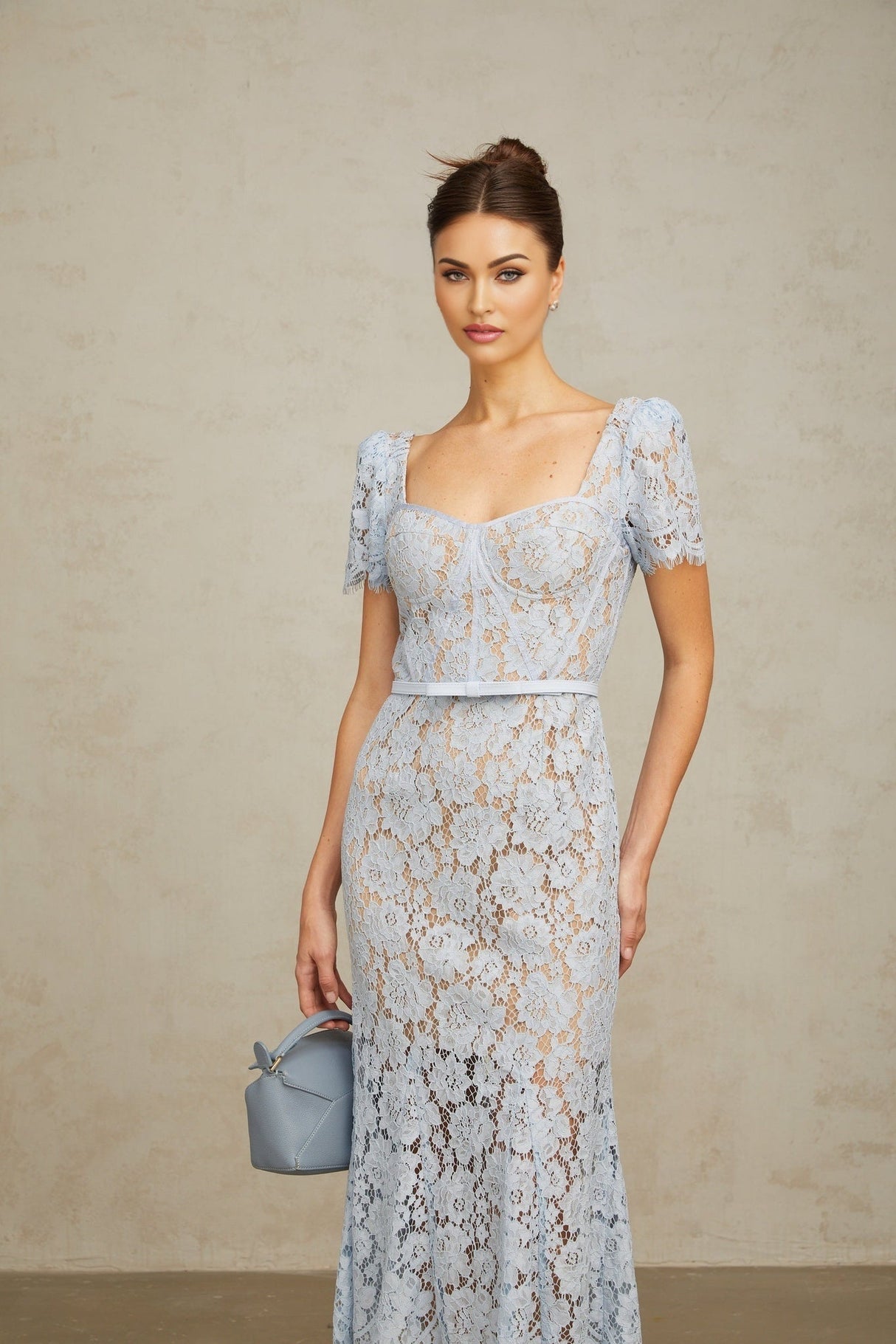 Woman wearing blue floral lace midi dress with boned bodice and fitted silhouette