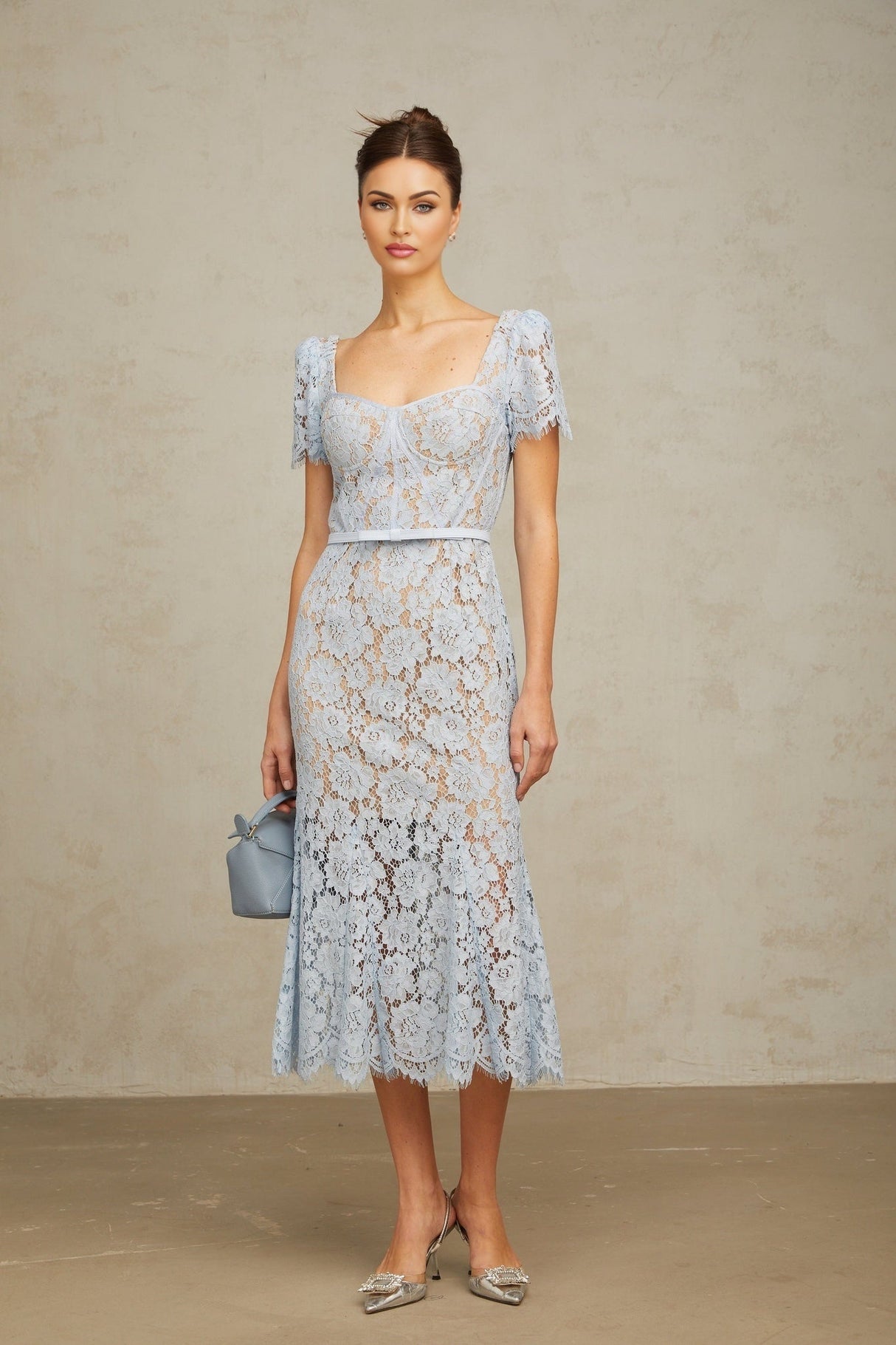 Woman wearing blue floral lace midi dress with boned bodice and fitted silhouette
