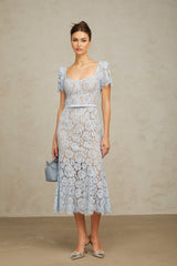 Woman wearing blue floral lace midi dress with boned bodice and fitted silhouette