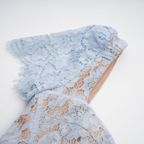 Woman wearing blue floral lace midi dress with boned bodice and fitted silhouette