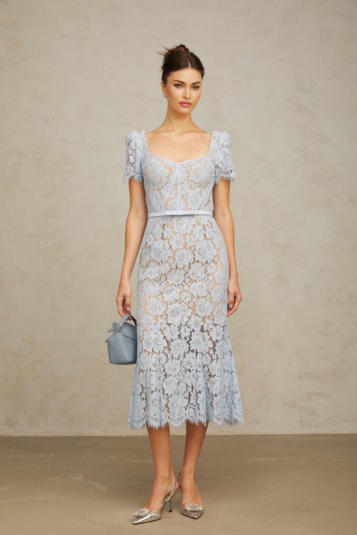 Woman wearing blue floral lace midi dress with boned bodice and sweetheart neckline