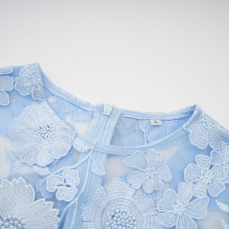 Woman wearing blue midi dress with floral applique details
