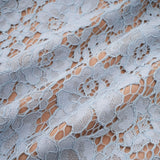 Woman wearing blue midi dress with floral lace pattern and boned bodice