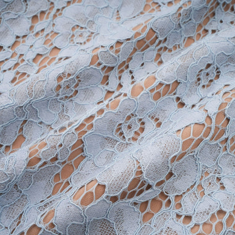 Woman wearing blue midi dress with floral lace pattern and boned bodice